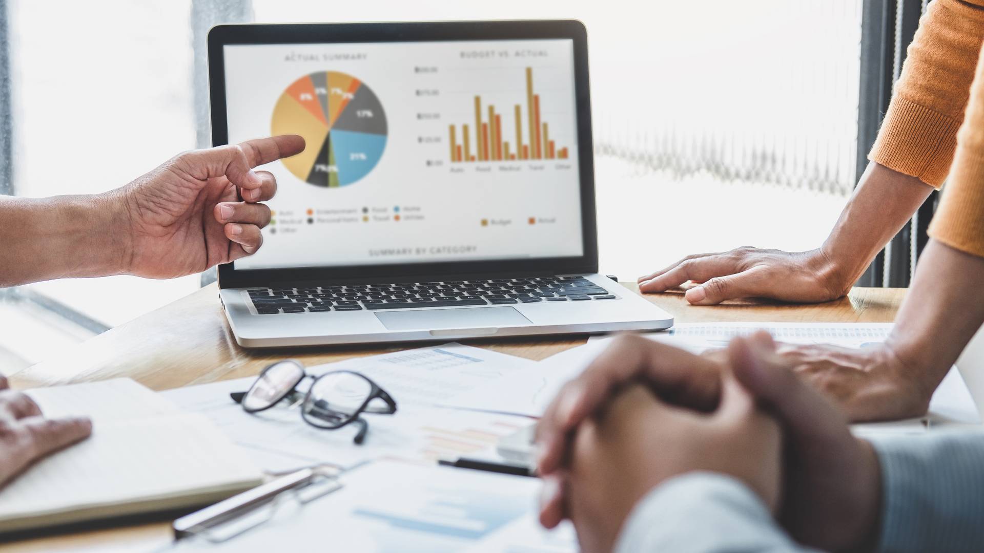 A team of business professionals collaboratively analyzing data and charts during a strategy planning session