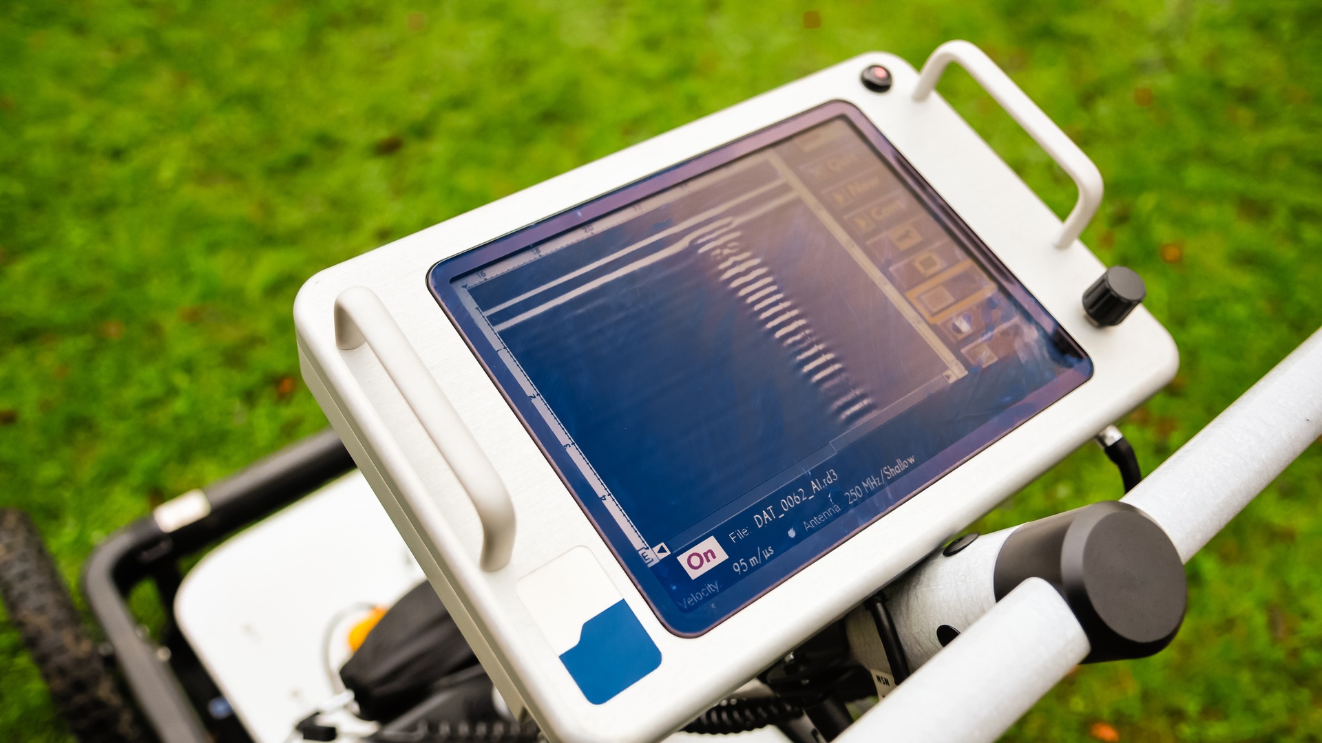 A close-up of the touchscreen of a ground-penetrating radar screen mounted to the top of the radar detector.