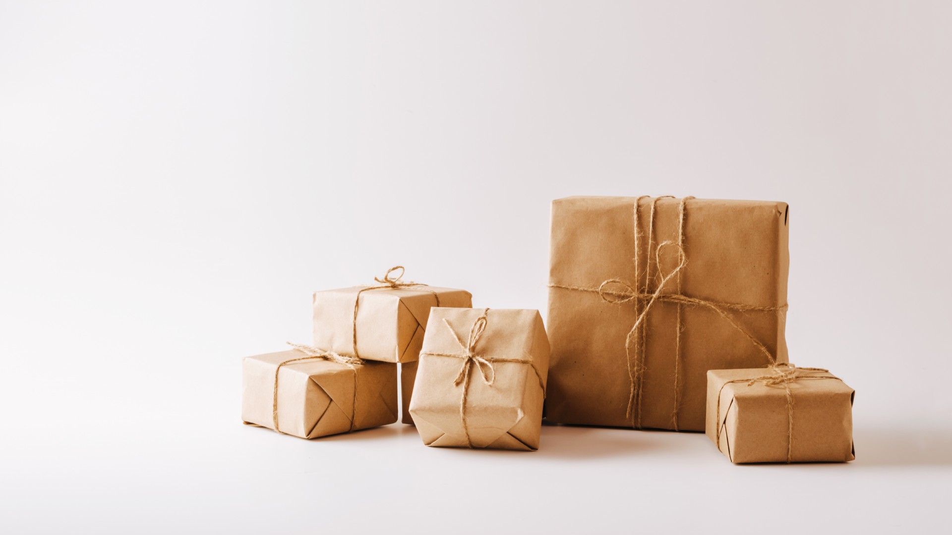 A small set of packages wrapped in brown Kraft paper with twine around the wrapping. There are a few different box sizes.